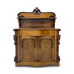 Mid-19th century rosewood chiffonier, raised back with scroll and leaf carved shaped pediment, serpentine top over drawer and double cupboard with scrollwork decoration, on shaped plinth base