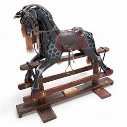 Retailed by Harrods - 'Millennium Limited Edition' rocking horse, dappled black finish with leather saddle and stirrups, on trestle base with turned pedestals, brass plaque inscribed 'Special Millennium Limited Edition To Mark Year 2004 Serial No. 325' 