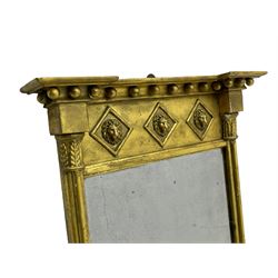 Regency giltwood and gesso pier mirror, projecting moulded cornice with globular mounts, the frieze decorated with three lion masks within lozenges, cluster column uprights with leaf decorated capitals, bevelled mirror plate