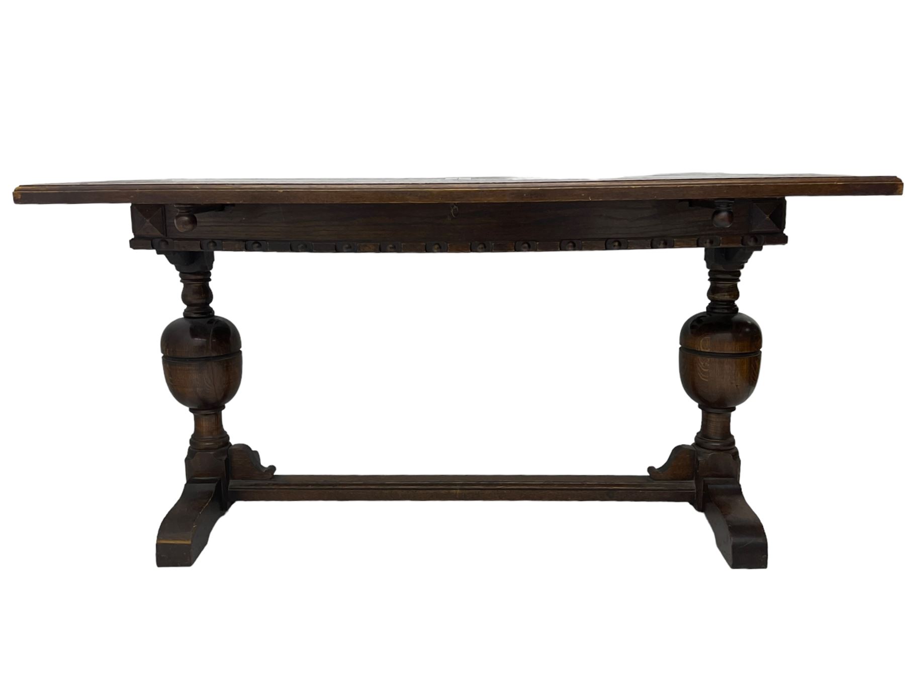 Early 20th century oak extending table, moulded rectangular top, pull-out action with fold-out leaf, on turned cup and cover pedestals and sledge feet, united by moulded stretcher 