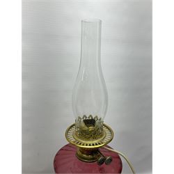 Victorian corinthian column oil lamp, with red glass reservoir and later converted for electricity, H45cm