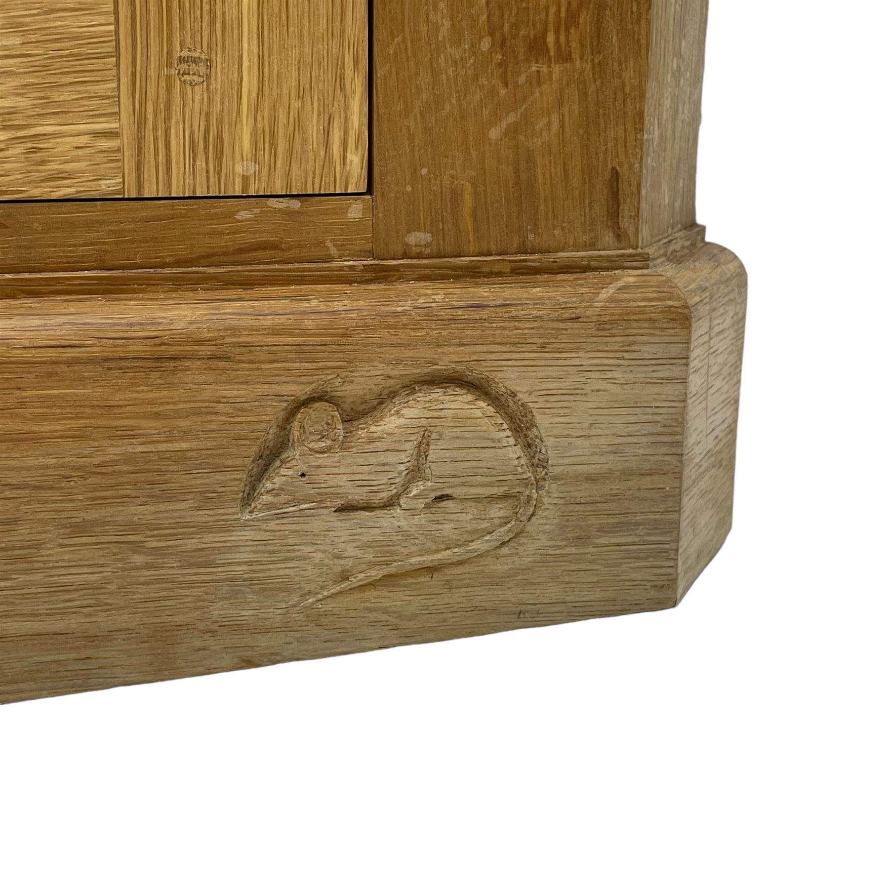 Mouseman - oak floor standing corner cupboard, fall front compartment over single panelled door, with wrought metal loop handle and latch, on moulded plinth base, carved in relief with mouse signature, by the workshop of Robert Thompson, Kilburn 