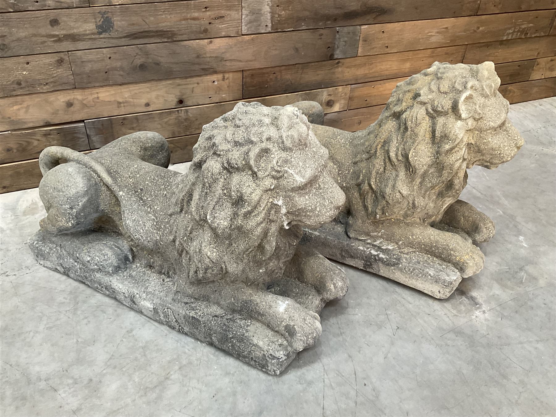 Pair of large cast stone Langport recumbent garden lions, rectangular plinth base