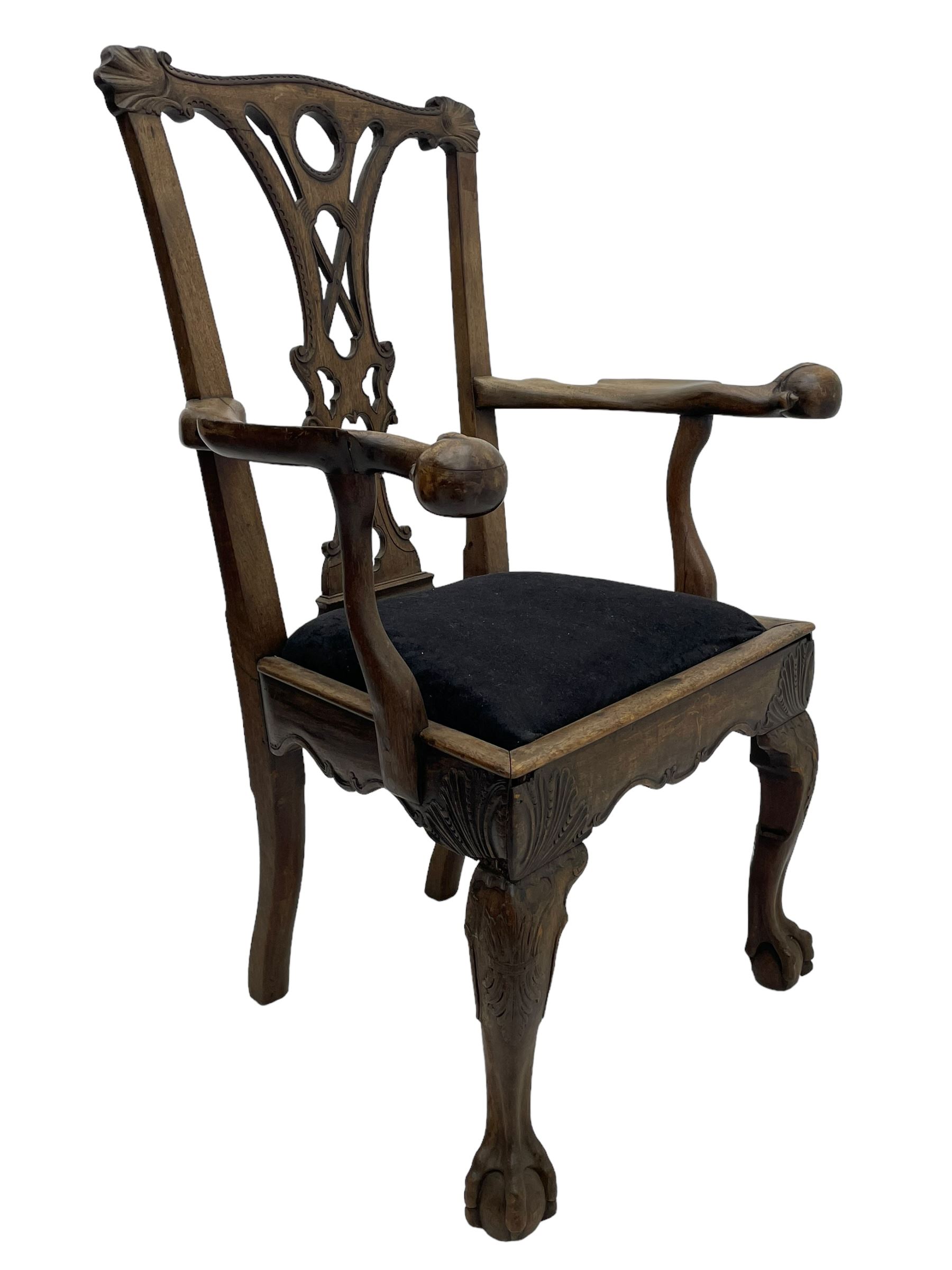 Unusual 18th century mahogany elbow chair, the shaped cresting rail with projecting shell carved ears, pierced and scroll carved splat over drop-in upholstered seat, shaped arms with ball and claw carved terminals, the seat rails carved with shell cartouches, on foliate carved cabriole supports with ball and claw feet 