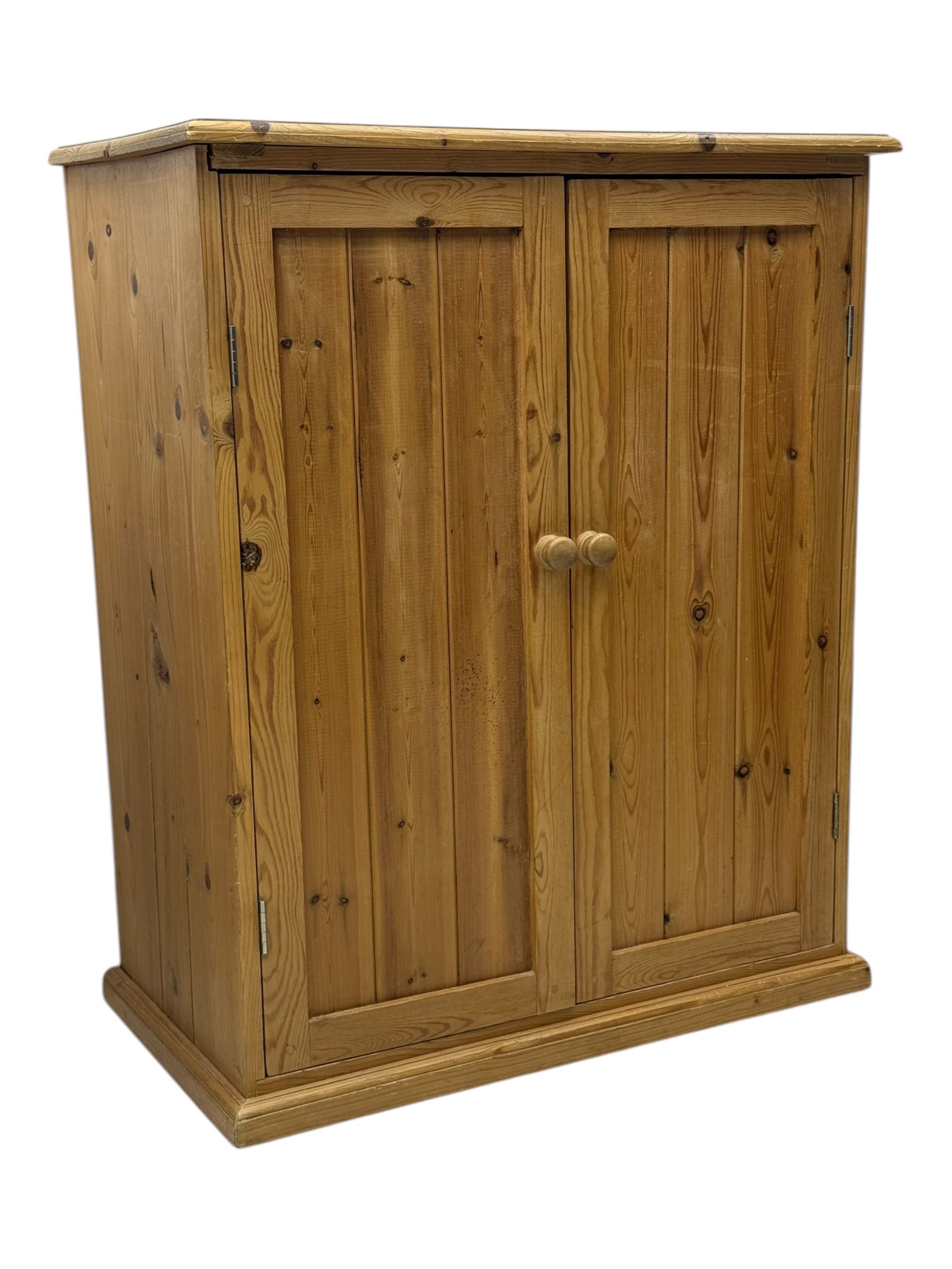 Pine cupboard, rectangular moulded top over two panelled doors enclosing two plank shelves, on plinth base