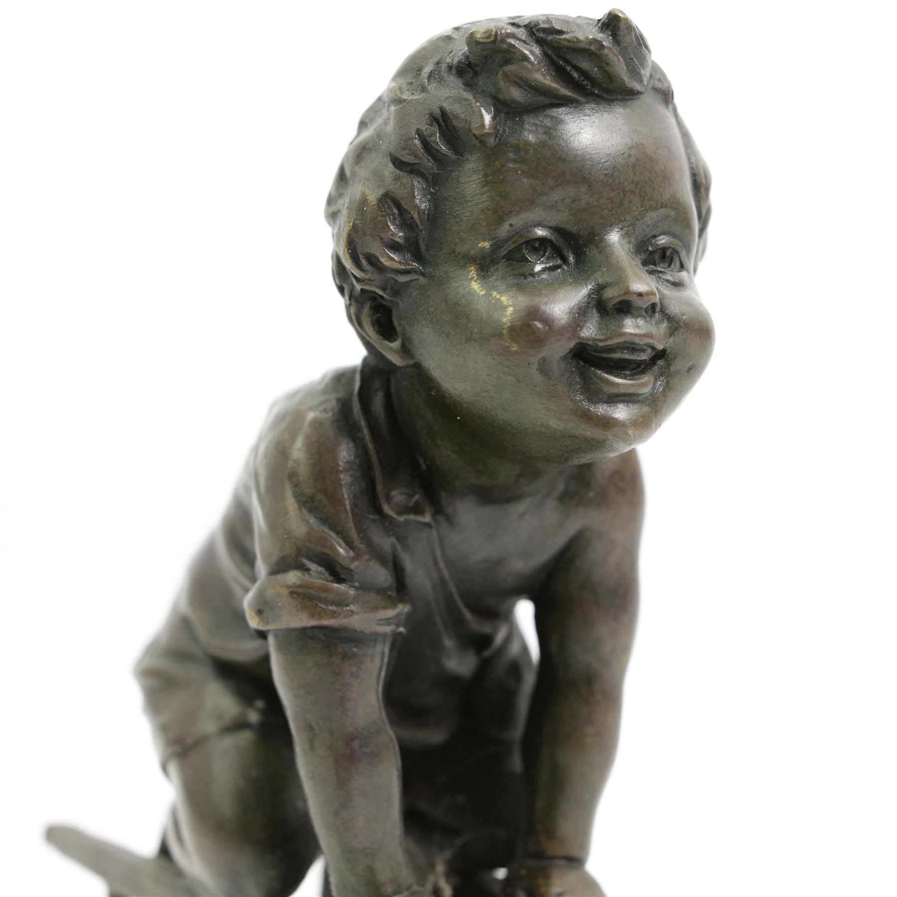 After Juan Clara (Spanish 1875-1957) - Bronze of a child playing on an upturned stool H15cm, signed underneath stool 