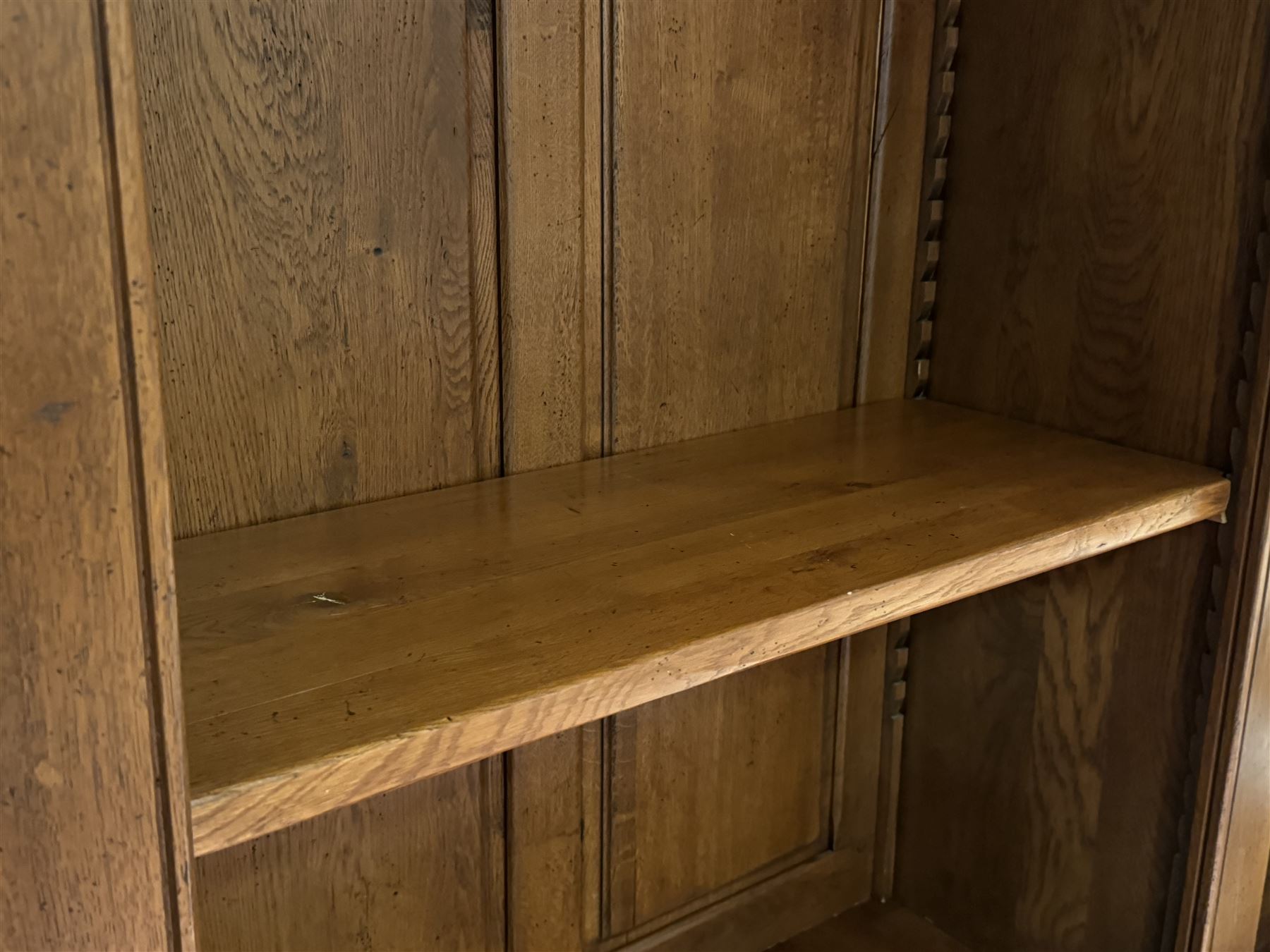 Large 20th century oak dresser, projecting cornice over open arched central section with two shelves, flanked by two panelled cupboards with two shelves, lower section with three drawers above three cupboards, on stile supports 