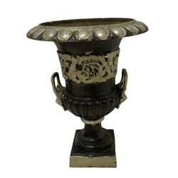 20th century cast iron Campana-shaped urn on plinth, with scrolling foliate relief decoration, in ebonised and silver painted finish