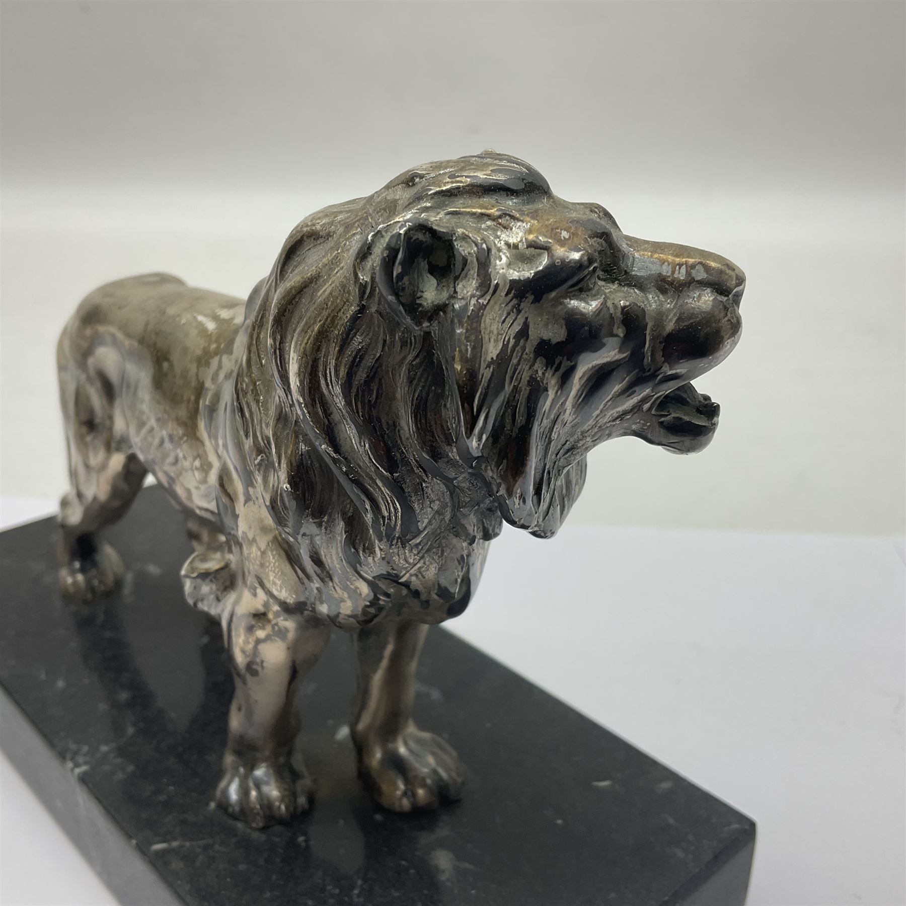 Silvered metal lion, upon a rectangular base, H12cm