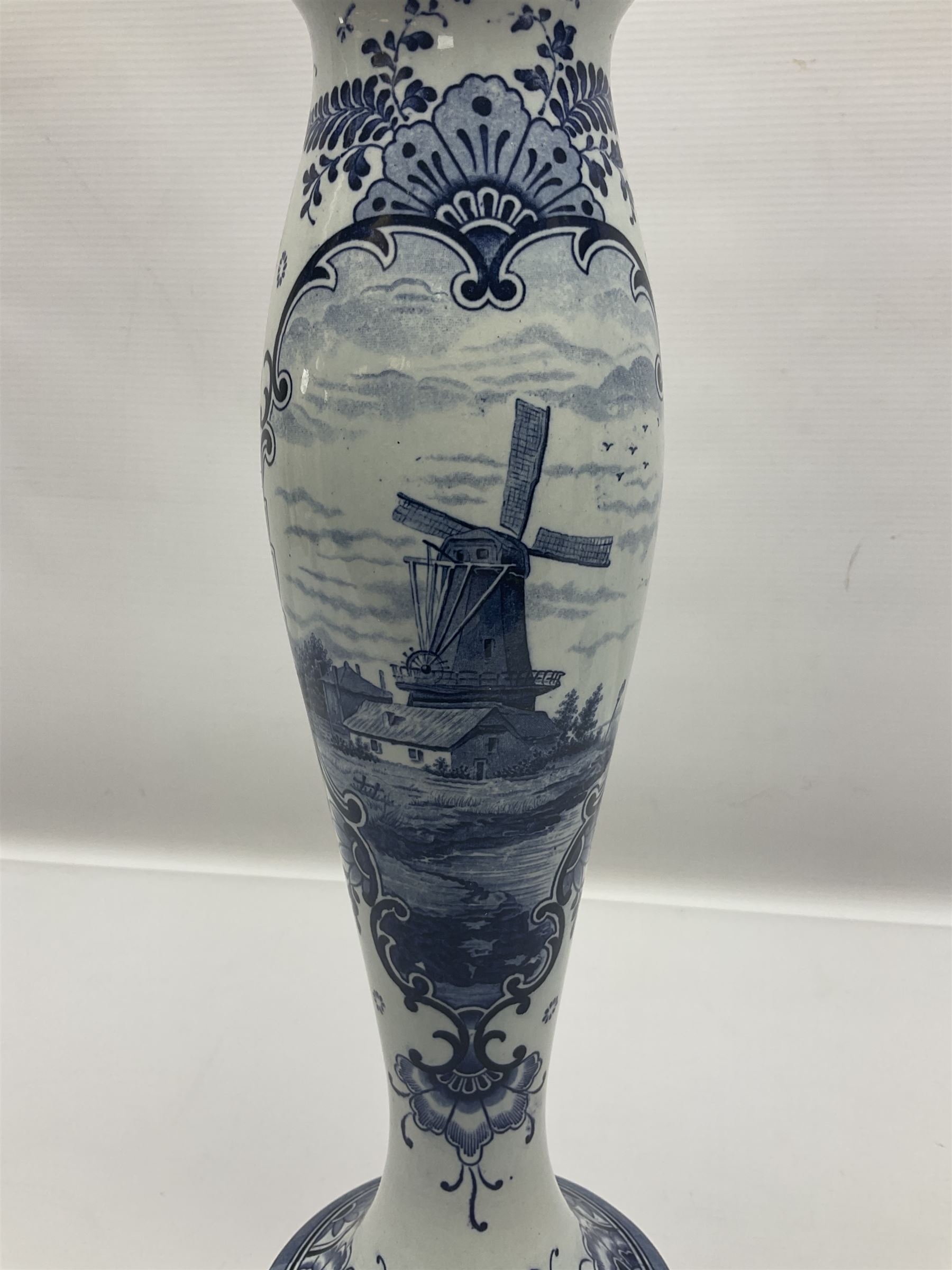 Pair of Delft blue and white vases, of elongated baluster form with shaped fluted rim, one depicting a Dutch sailing scene, the other a Dutch windmill scene, with painted mark beneath, H35.5cm