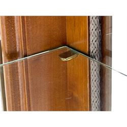 20th century cherry wood display cabinet, projecting cornice over two glazed doors with bevelled panes flanked by fluted support columns, enclosing three adjustable glass shelves with mirror-back surface, supported by shaped bracket feet