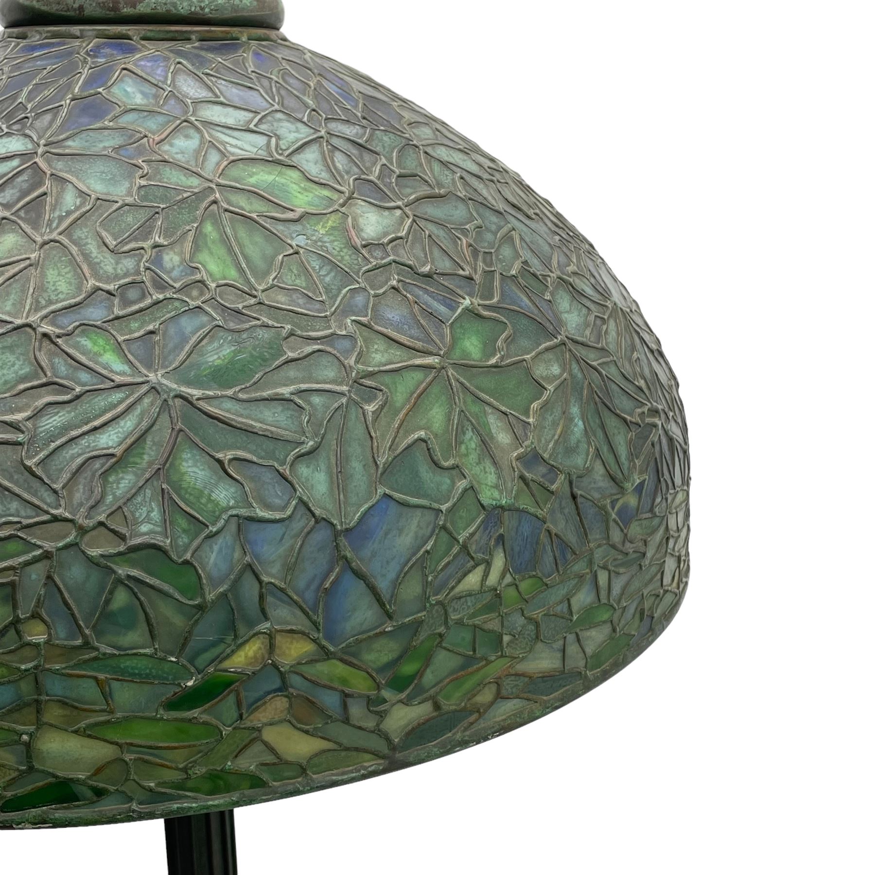 In the manner of Tiffany & Co. - bronze 'Chased Pod' design floor lamp, 'Maple Leaf' dome leaded glass shade decorated with flowers in blue and green shades, six branches on column decorated with stylised trailing stems terminating to circular base with stylised plant decoration, on scrolled feet, the base stamped 'Tiffany Studios New York 379' the inner shade stamped 'Tiffany Studios New York [...]'