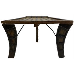 19th century Indian bullock / ox cart converted coffee table, trapezoidal top with applied metal decoration and iron stretchers, raised on three swept supports with stud decoration