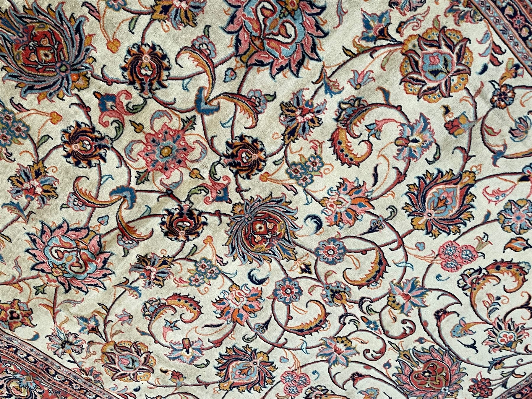 Persian Sarough ivory ground rug, the field decorated with curled leafy branches and palmettes, crimson ground border decorated with further palmettes and floral sprays, within guard stripes 