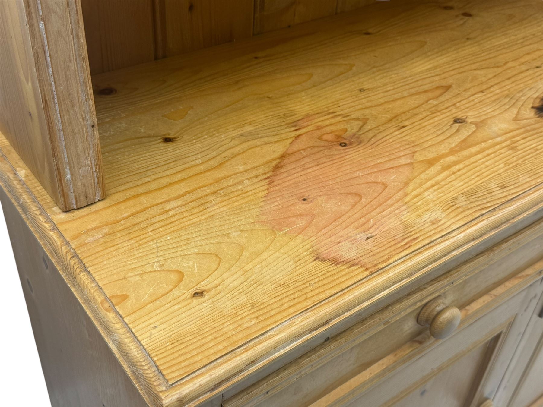 Traditional design waxed pine dresser, upper section with moulded cornice over scalloped frieze, fitted with two open shelves and four drawers, lower section with three drawers over three panelled cupboards, on plinth base