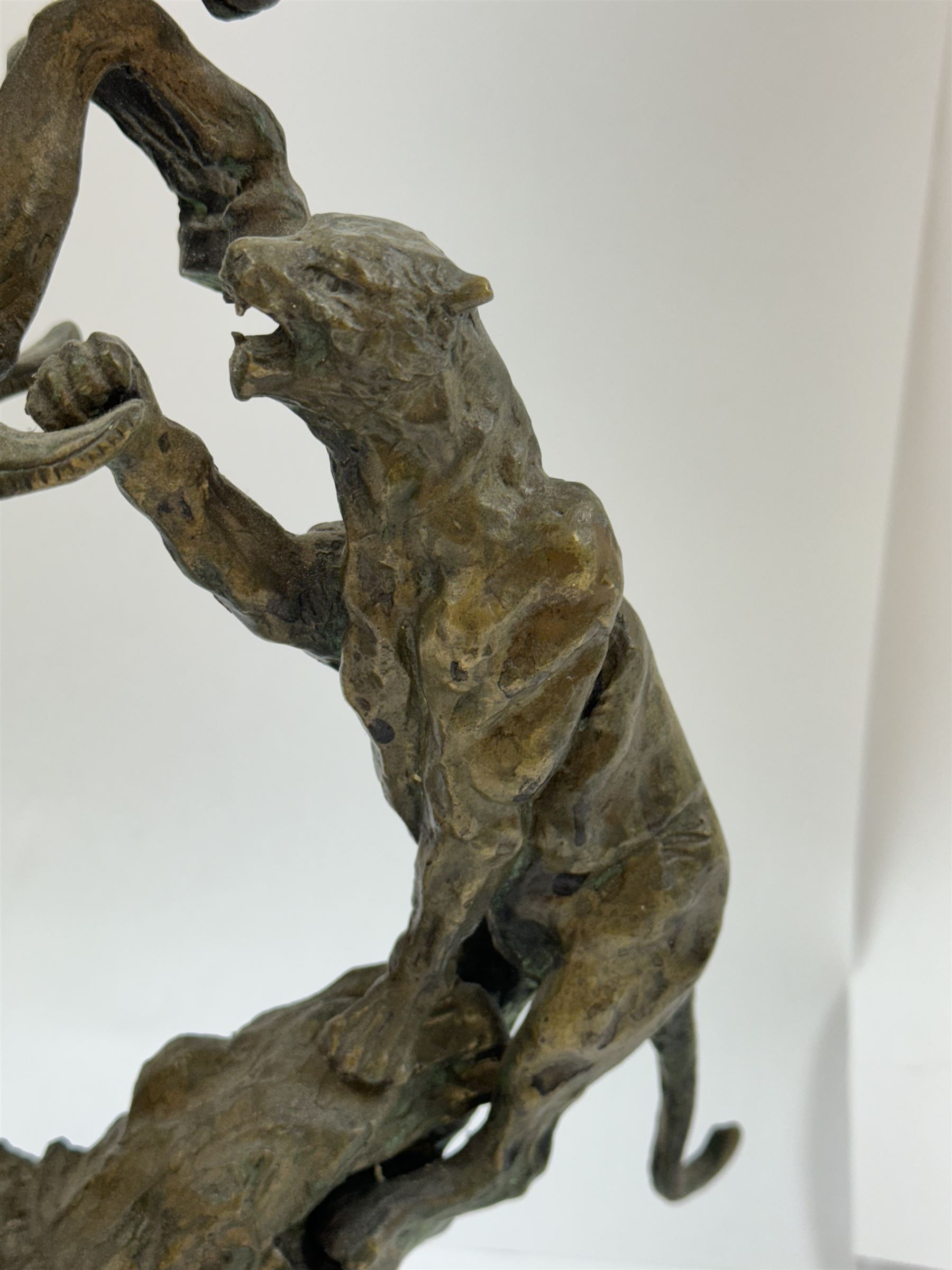 After Charles Marion Russell; Bronzed sculpture depicting man on horseback fighting a mountain lion, H42cm