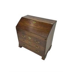 George III oak bureau, the fall front enclosing stepped pigeons holes drawers and sunken well with sliding lid, fitted with three long drawers, on foliage carved s-scroll feet