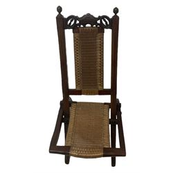 Victorian Aesthetic Movement mahogany framed folding campaign chair, pierced and carved cresting rail with carved and chamfered uprights, rattan back and seat