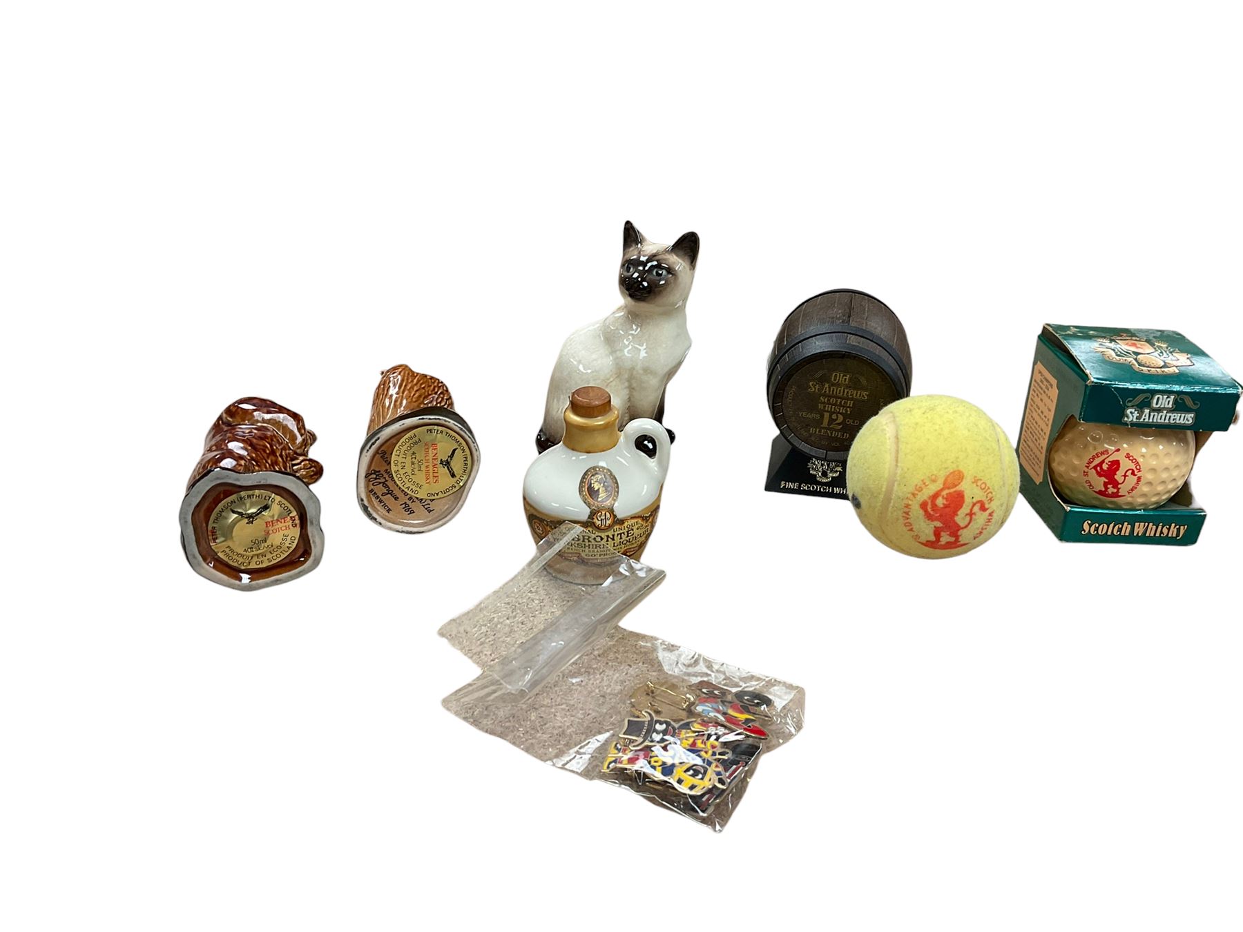 Six whisky miniatures in novelty decanters, together with Beswick cat, and nine Robertsons Golly badges