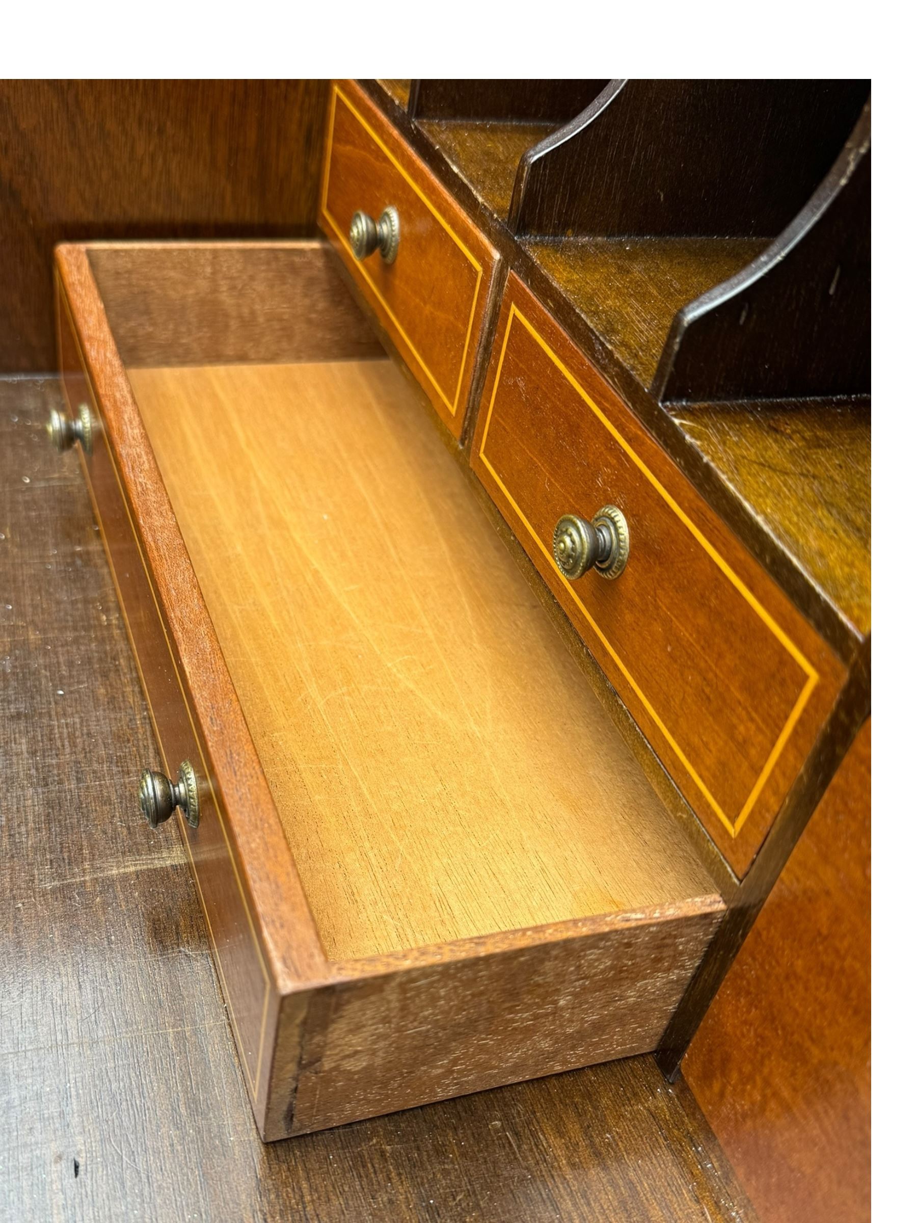 Mid-to-late 20th century inlaid mahogany bureau, inlaid floral medallion to the top, the fall front opening to reveal fitted interior with pigeonholes, small drawers and central cupboard, green inset writing surface with gilt tooling, four drawers below with brass handles, raised on shaped bracket feet