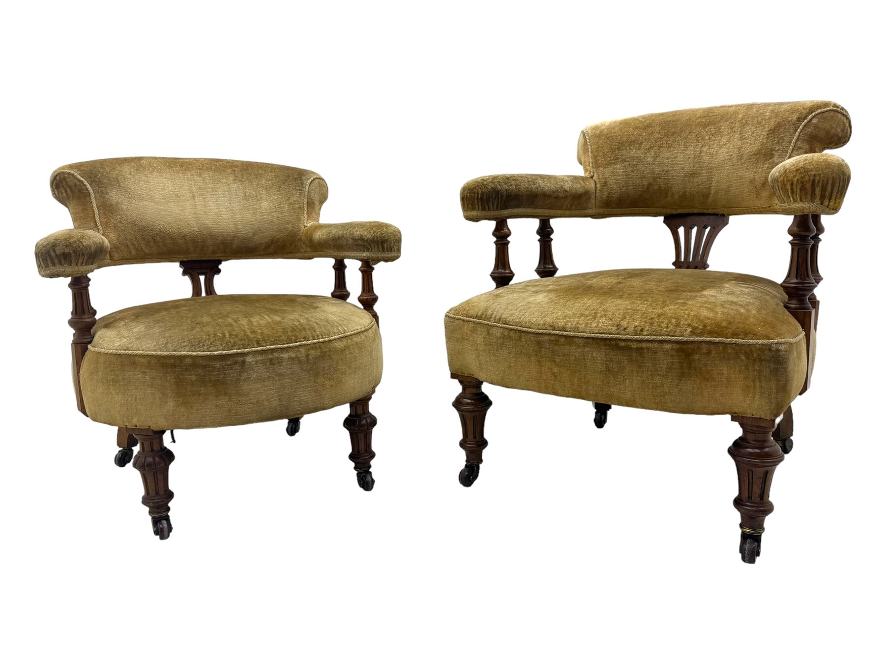 Victorian pair of mahogany armchairs, upholstered in gold velvet fabric, each with curved back, pierced splat and scroll arms, one with rounded seat and the other square, on turned front supports with castors