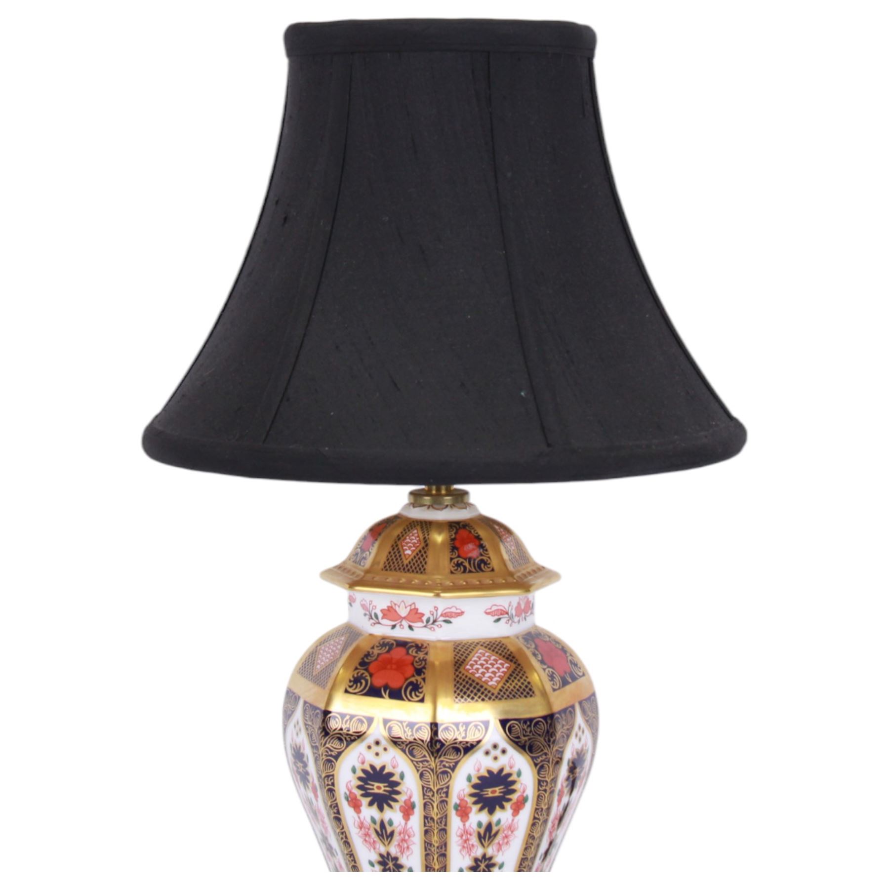 Pair of 20th century Royal Crown Derby 1128 Imari pattern table lamps, each of octagonal baluster form, with black fabric shades, each with printed mark beneath and date cods for 1996 and 1998, base H23cm, including shade H43cm