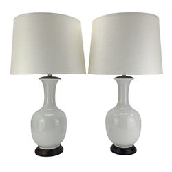 Pair of Chinese ivory crackle glazed table lamps, each of bottle form, raised upon circular hardwood bases, H43cm excluding fitting