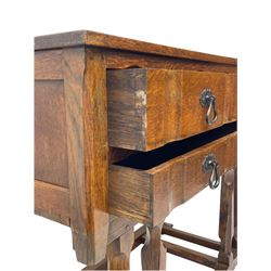 Arts & Crafts design oak chest on stand, rectangular top over two short and one long drawer, on a series of shaped and tapered supports with carved and beaded decoration, united by chamfered stretchers rails, on sledge feet 