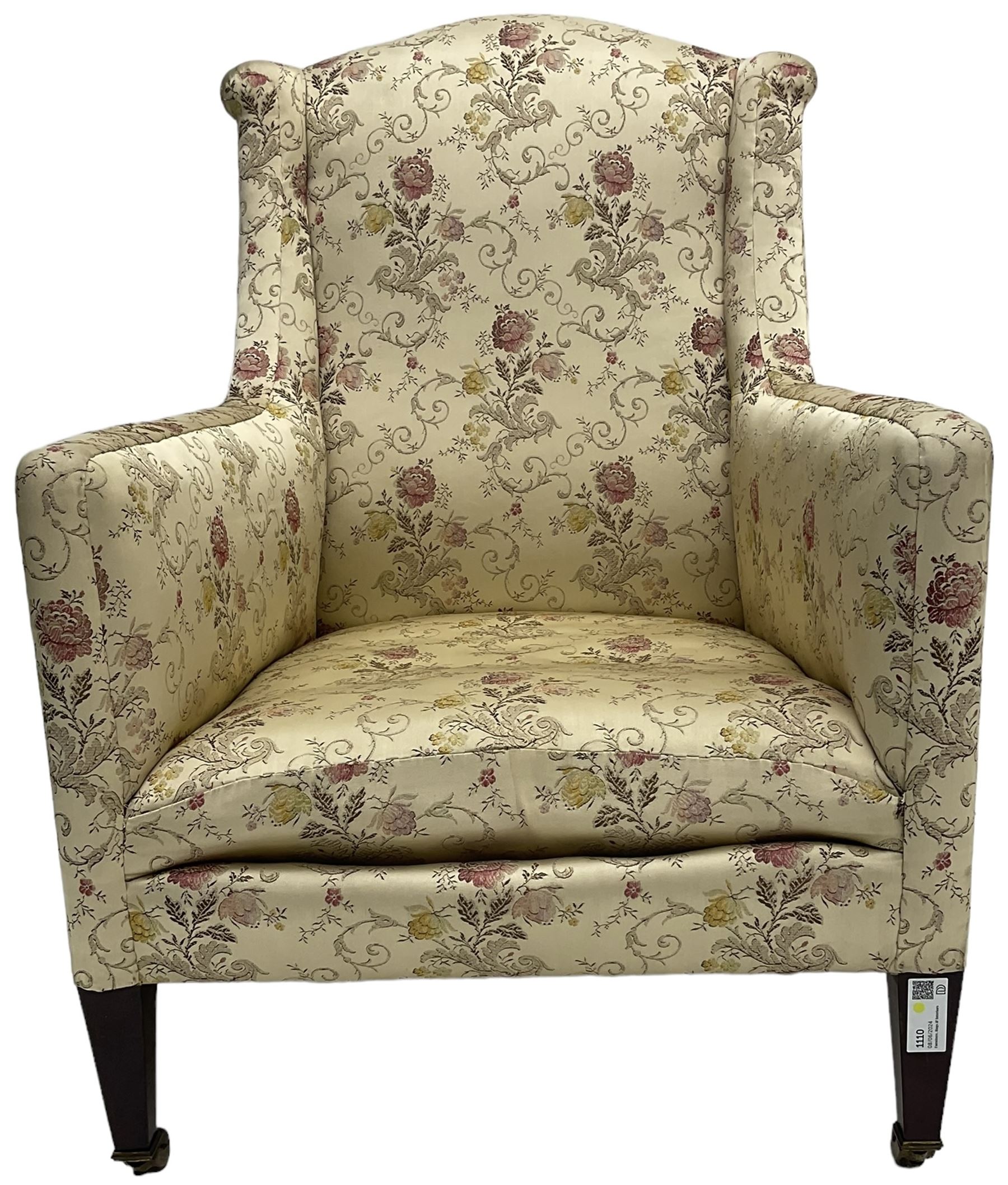 Edwardian hardwood-framed armchair, upholstered in floral pattern fabric, on square tapering front supports, brass and ceramic castors 