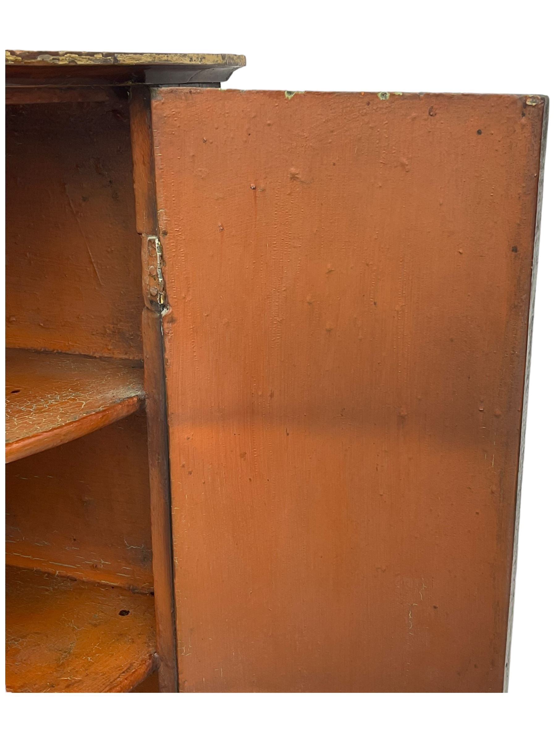 George III mahogany bow-front corner cupboard, enclosed by two figured doors with brass hinges and escutcheon, the painted interior fitted with three shelves 