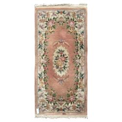 Chinese Aubusson design pink ground rug, the field decorated with an oval medallion filled with floral motifs in pastel shade, surrounded by floral garlands and foliate scrolls