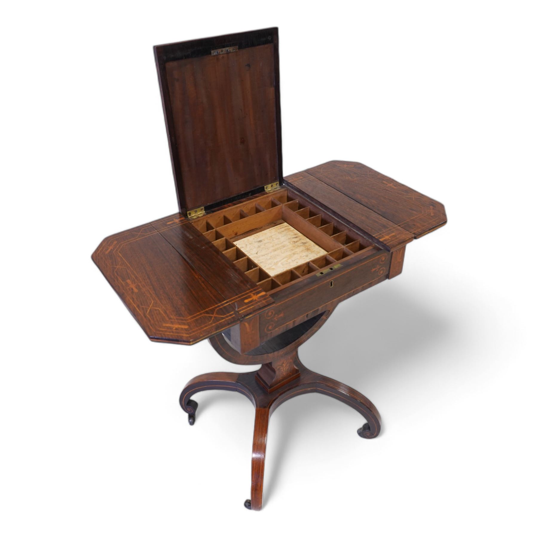 Victorian inlaid rosewood work or sewing table, the rectangular drop-leaf top with canted corners and inlaid with geometric banding, the hinged lid opening to reveal a central compartment surrounded by divisions, raised on a U-support terminating to arched supports with castors