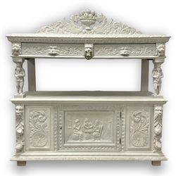 Victorian white painted heavily carved oak buffet, shaped pediment decorated with central urn filled with fruit flanked by winged beasts and scrolling acanthus leaves, moulded rectangular top carved with foliage, two drawers with Greenman mask handles over undertier, the upper tier supported by flute playing musicians, the lower section fitted with cupboard enclosed by panelled door carved with tavern scene, bead carved lower mouldings, on stile supports 