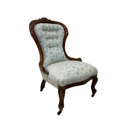 Victorian walnut nursing chair, the curved cresting rail carved with central cartouche and scroll leaves, upholstered in pale blue fabric decorated with trailing floral design, on cabriole front feet 