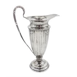 Early 20th century silver cream jug, of helmet form with faceted body and scroll handle, upon stepped circular foot, hallmarked Walker & Hall, date mark indistinct, H16.5cm