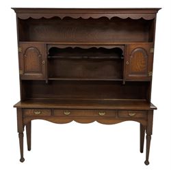 Early 20th century Georgian design oak dresser, projecting cornice with shaped apron over a three-tier plate rack with flanking fielded spice cupboards, the base fitted with three drawers, on turned supports