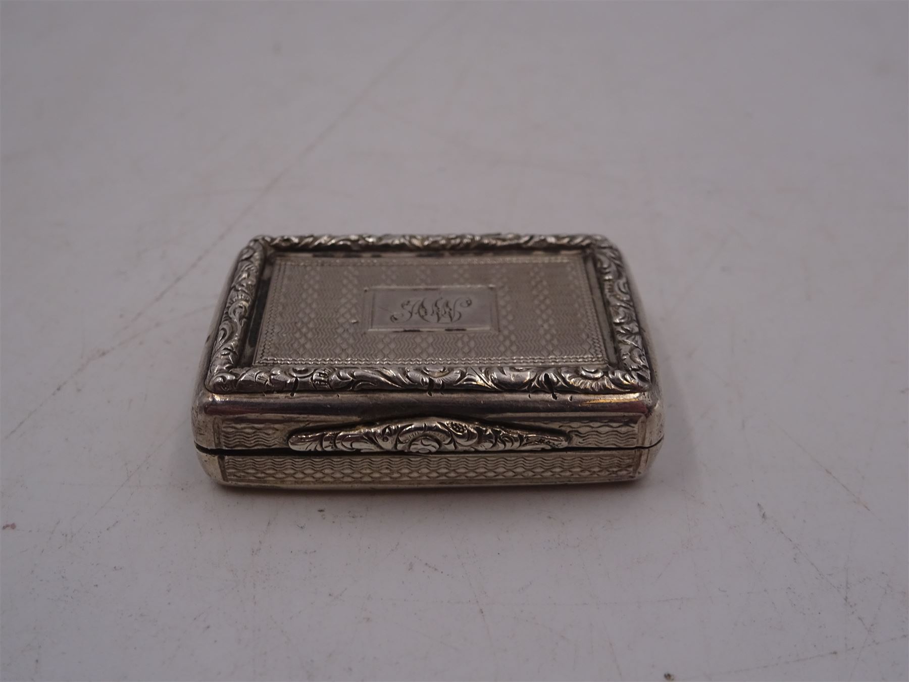 William IV silver vinaigrette, of rectangular form, with engine turned decoration throughout, chased scrolling borders and engraved cartouche to hinged cover, opening to reveal gilt interior with typical pierced cover, hallmarked Charles Reily & George Storer, London 1834, W3.7cm