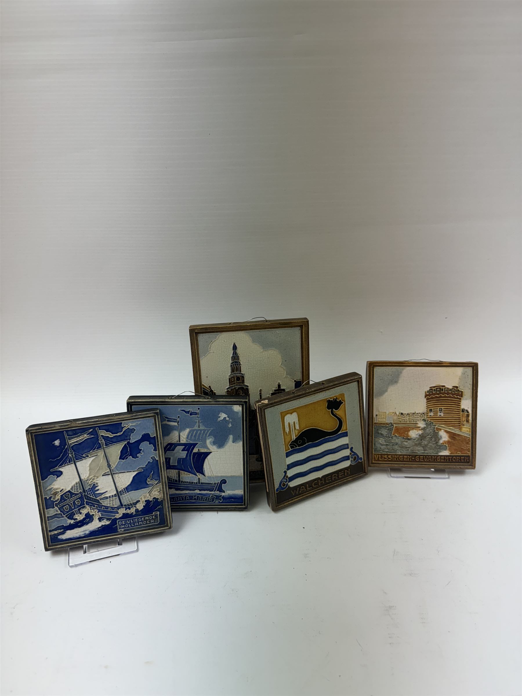 Five Dutch Westraven tiles, to include four square examples depicting maritime and similar scenes, and a rectangular example depicting a village scene, square tiles 10cm x 10cm, rectangular tile 15cm x 10cm