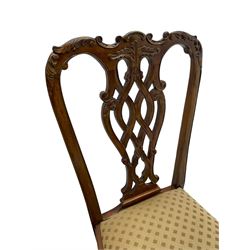 Set of twelve Chippendale design mahogany dining chairs, shaped cresting rail carved with foliage and C-scrolls, pierced interlaced splat with curled leaf decoration, upholstered drop-in seat, moulded seat rails, on scrolled acanthus carved cabriole supports with ball and claw feet 