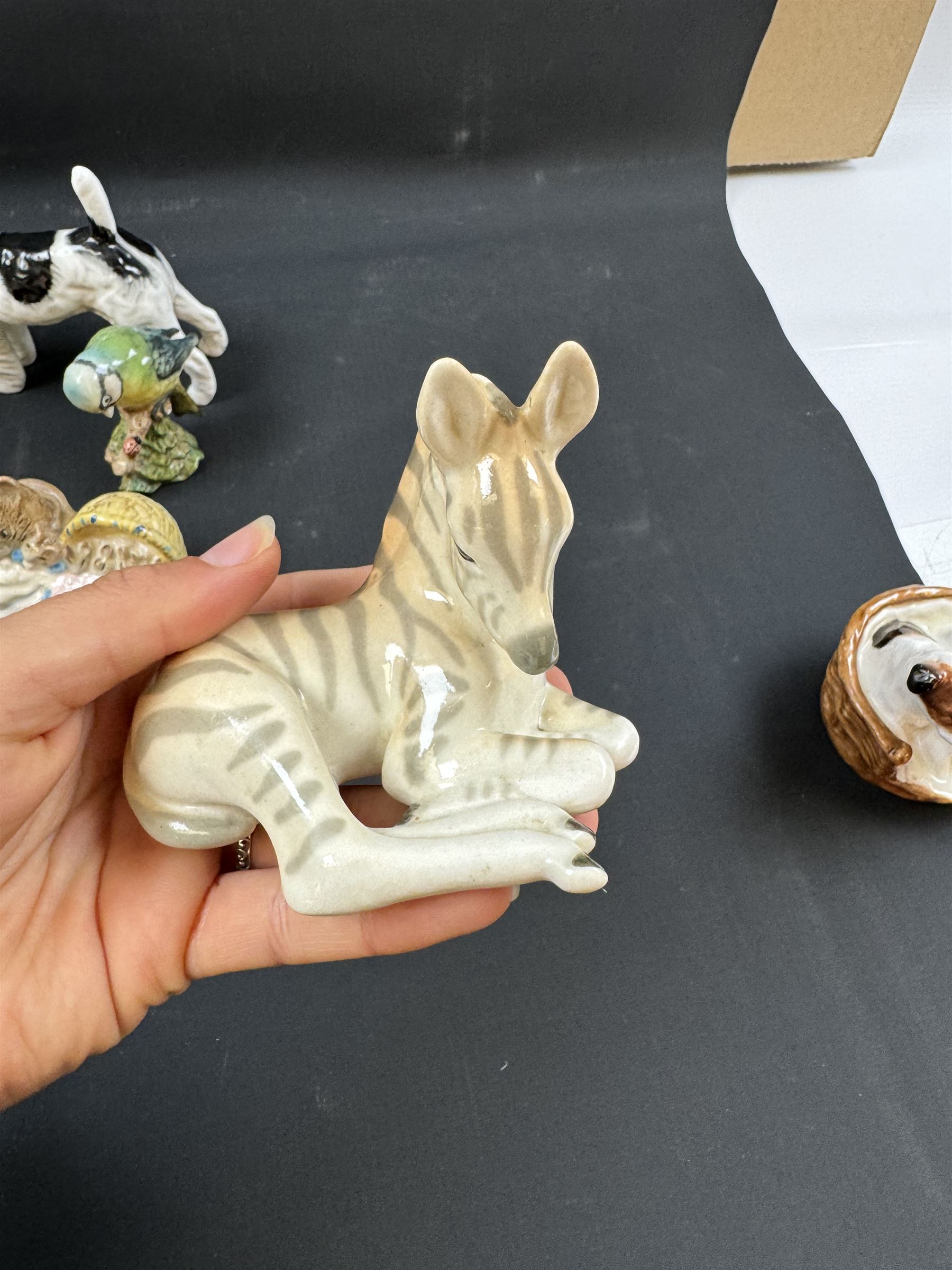 Two Royal Doulton figures of puppies in baskets, together with Beswick horse and other animal figures