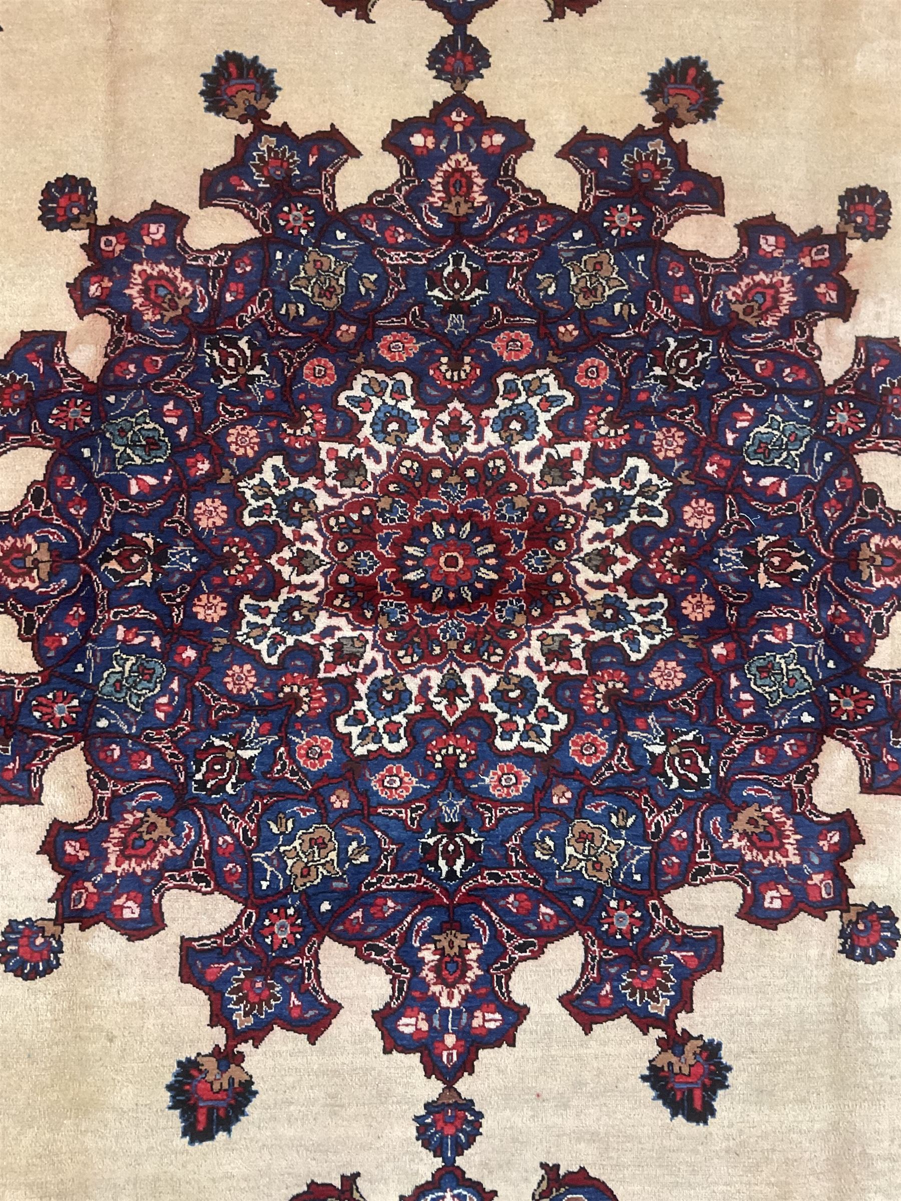 North East Persian Meshed carpet, the field with large central medallion decorated with stylised plant motifs, the field surrounded by panels, medallions and spandrels decorated with floral motifs, indigo ground border with overall floral design 