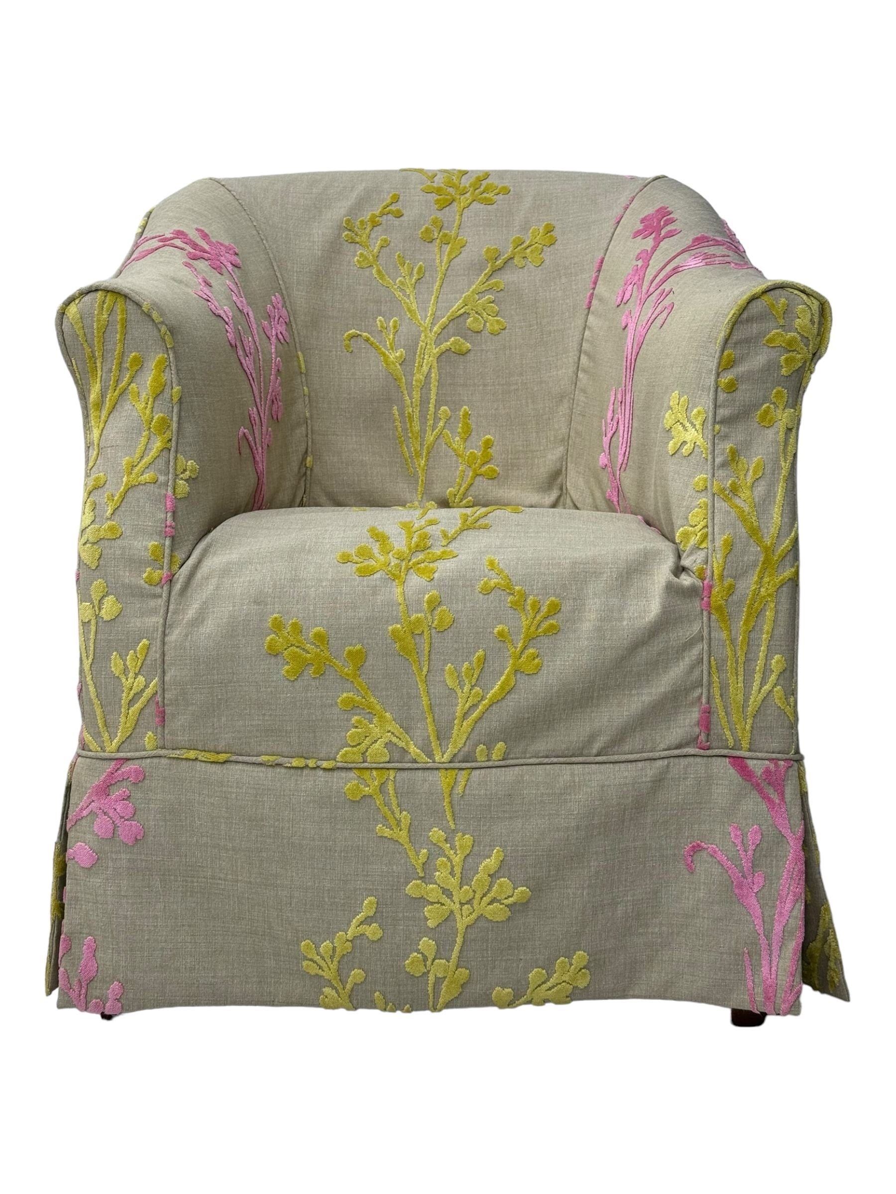 Pair of tub-shaped armchairs, mahogany frame loosely covered by branching floral pattern cover in pink and  yellow hues, skirted base, on concealed splayed rear and tapered front supports