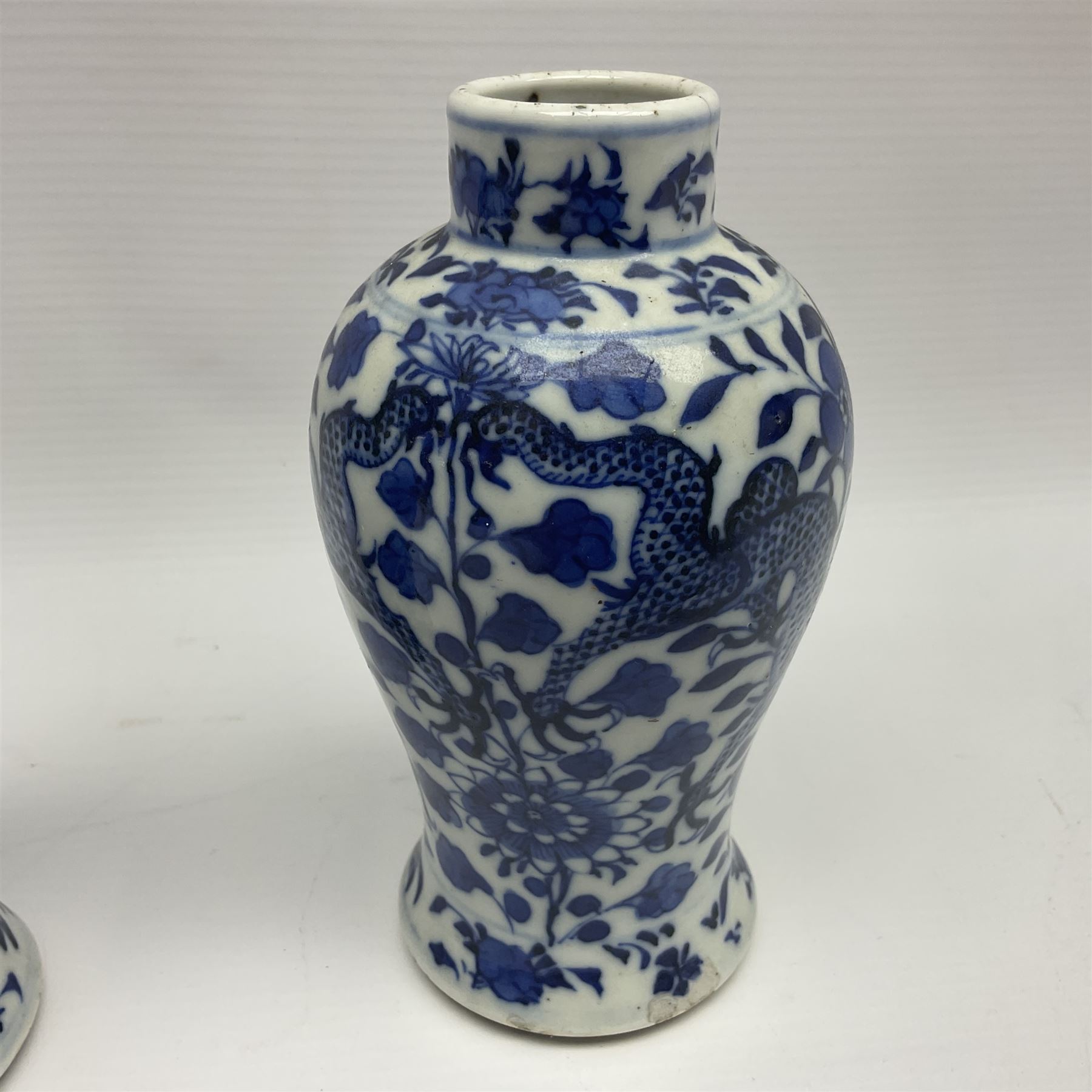 Pair of late 19th/early 20th century Chinese blue and white vases, each of baluster form, painted with dragons amidst flowers, each with Kangxi character marks beneath, H14cm 