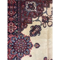 North East Persian Meshed carpet, the field with large central medallion decorated with stylised plant motifs, the field surrounded by panels, medallions and spandrels decorated with floral motifs, indigo ground border with overall floral design 