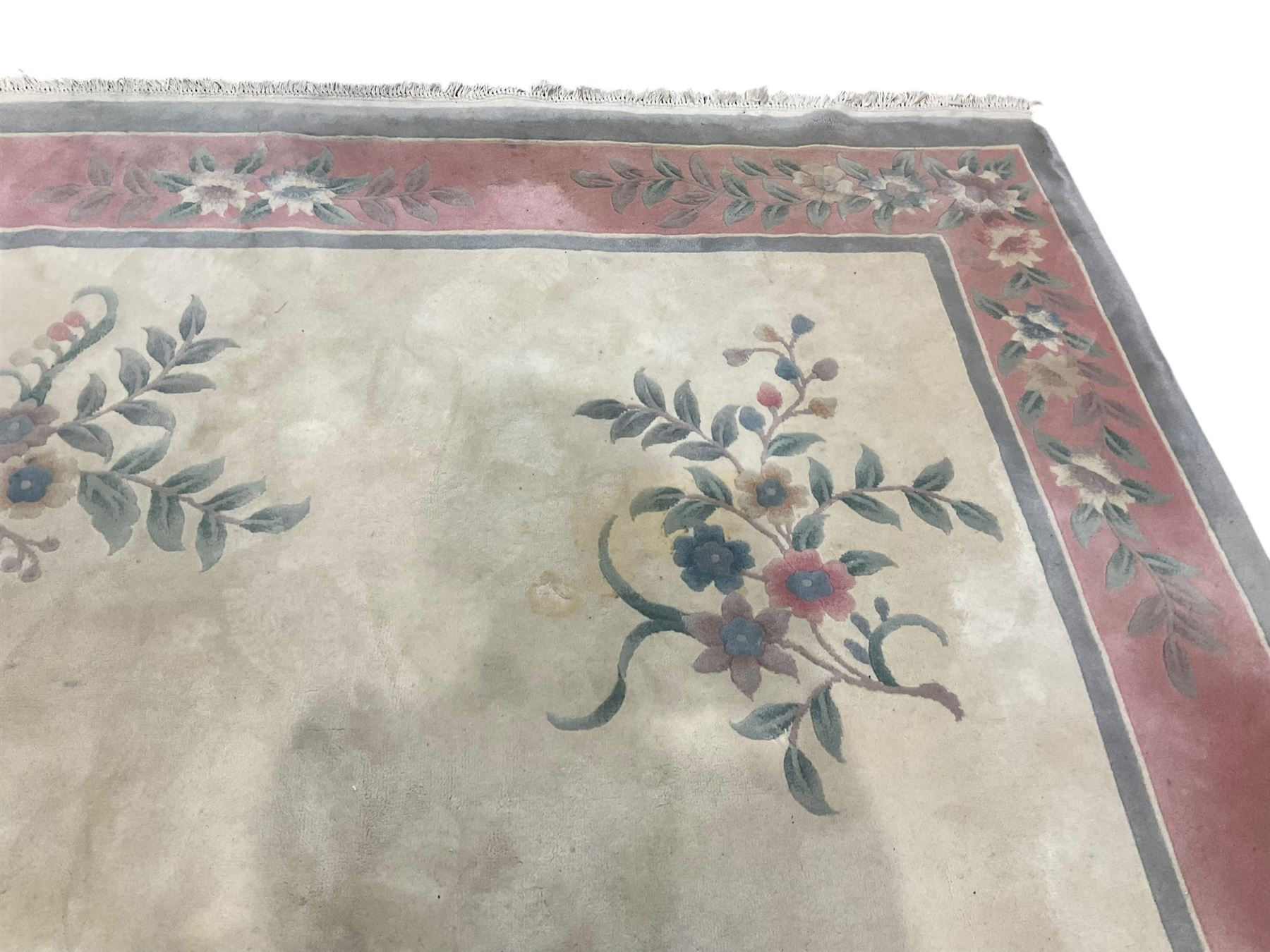 Chinese ivory ground washed woollen carpet, the field decorated with five large floral motifs with extending leafage, the wide rose guard band decorated with further floral patterns