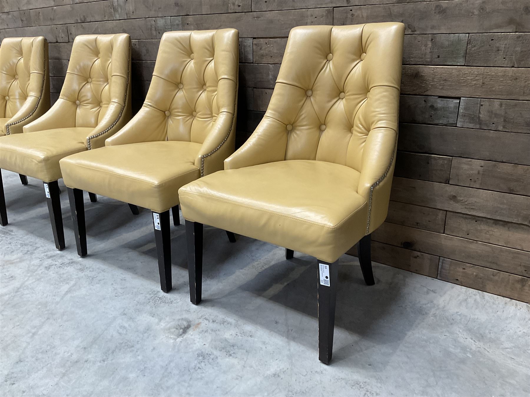 Four high back chairs upholstered in buttoned beige leather, studded detail, rosewood legs