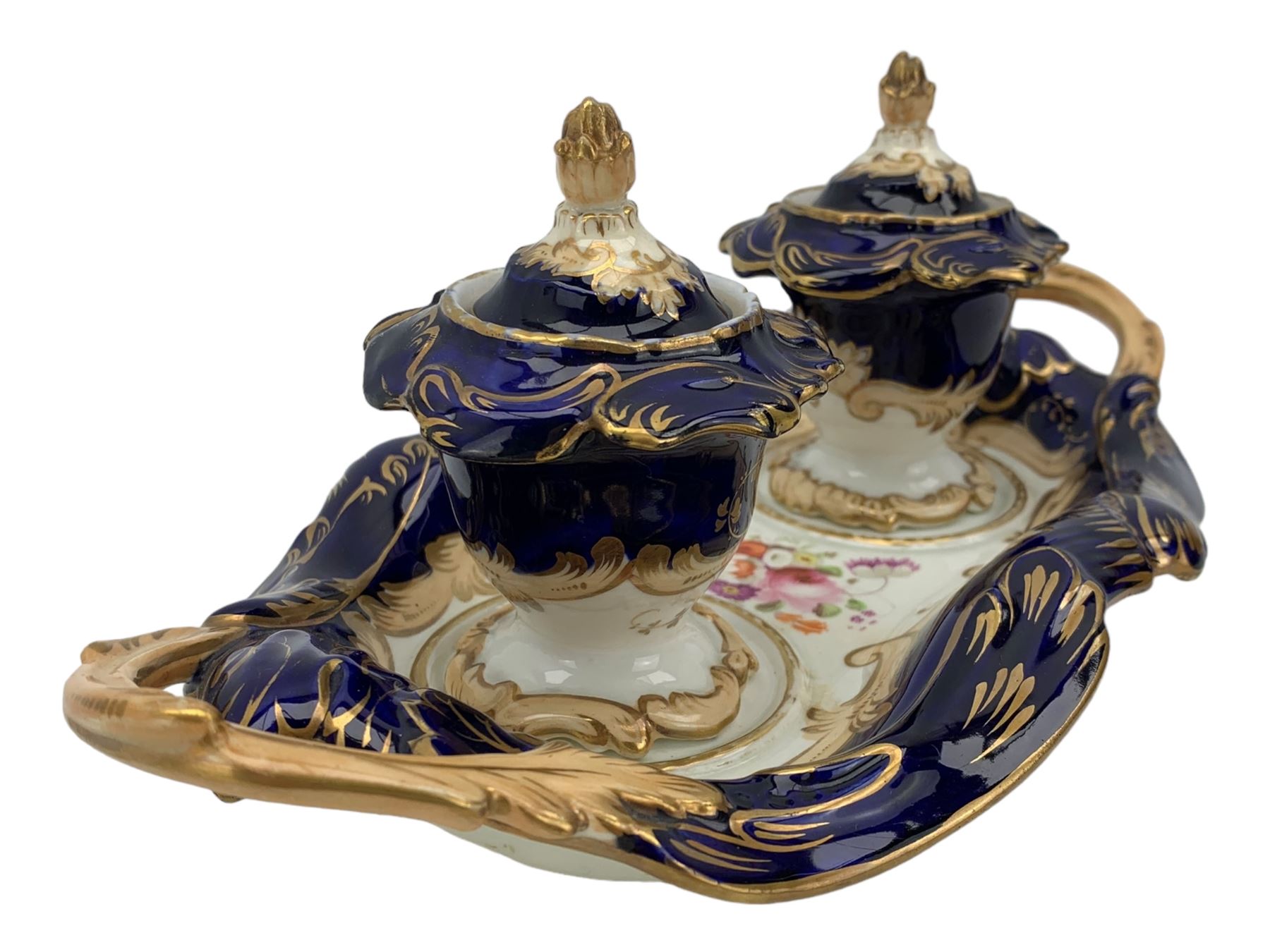 19th century porcelain inkstand, the oblong twin handled base centrally painted with a floral bouquet, flanked by two footed inkwells and covers, with rococo-inspired acanthus moulded borders and handles, pattern no. 2/3339, L26.5cm 