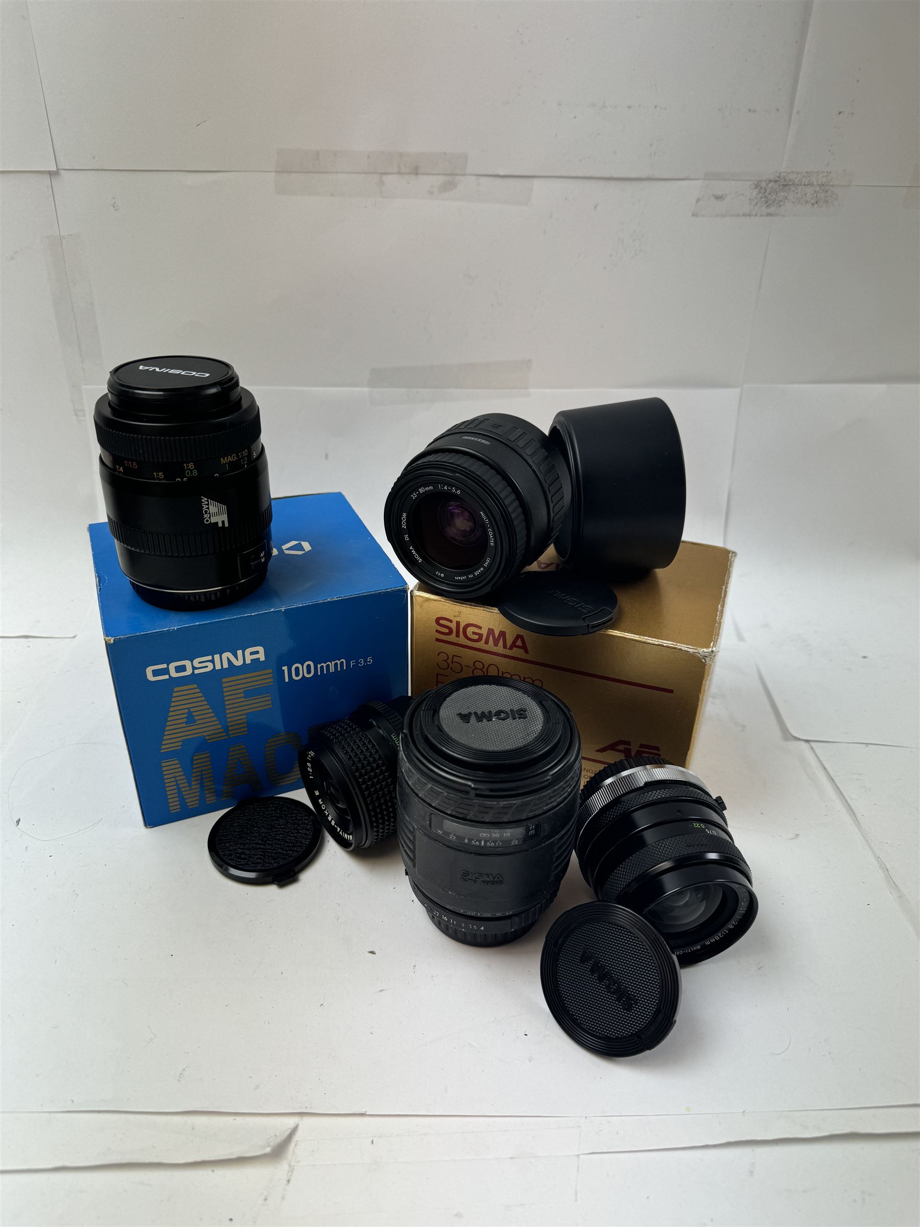 Group of camera lenses, comprising Cosina 100mm 1:3.5 MC Macro lens serial no. 9924159, Sigma DL Zoom 35-80mm 1:4-5.6 serial no 2031995, both boxed, Sigma UC Zoom 70-210mm 1:4-5.6 lens serial no. 1014147 and a Sigma Mini-Wide 1:2.8 f=28mm lens serial no. 261735, etc