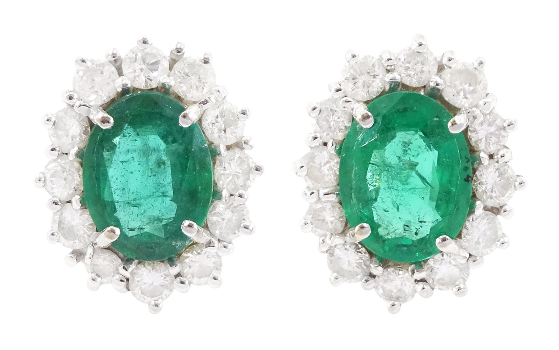 Pair of 18ct white gold oval cut emerald and round brilliant cut diamond cluster stud earrings, hallmarked, total emerald weight approx 2.00 carat, total diamond weight approx 1.20 carat