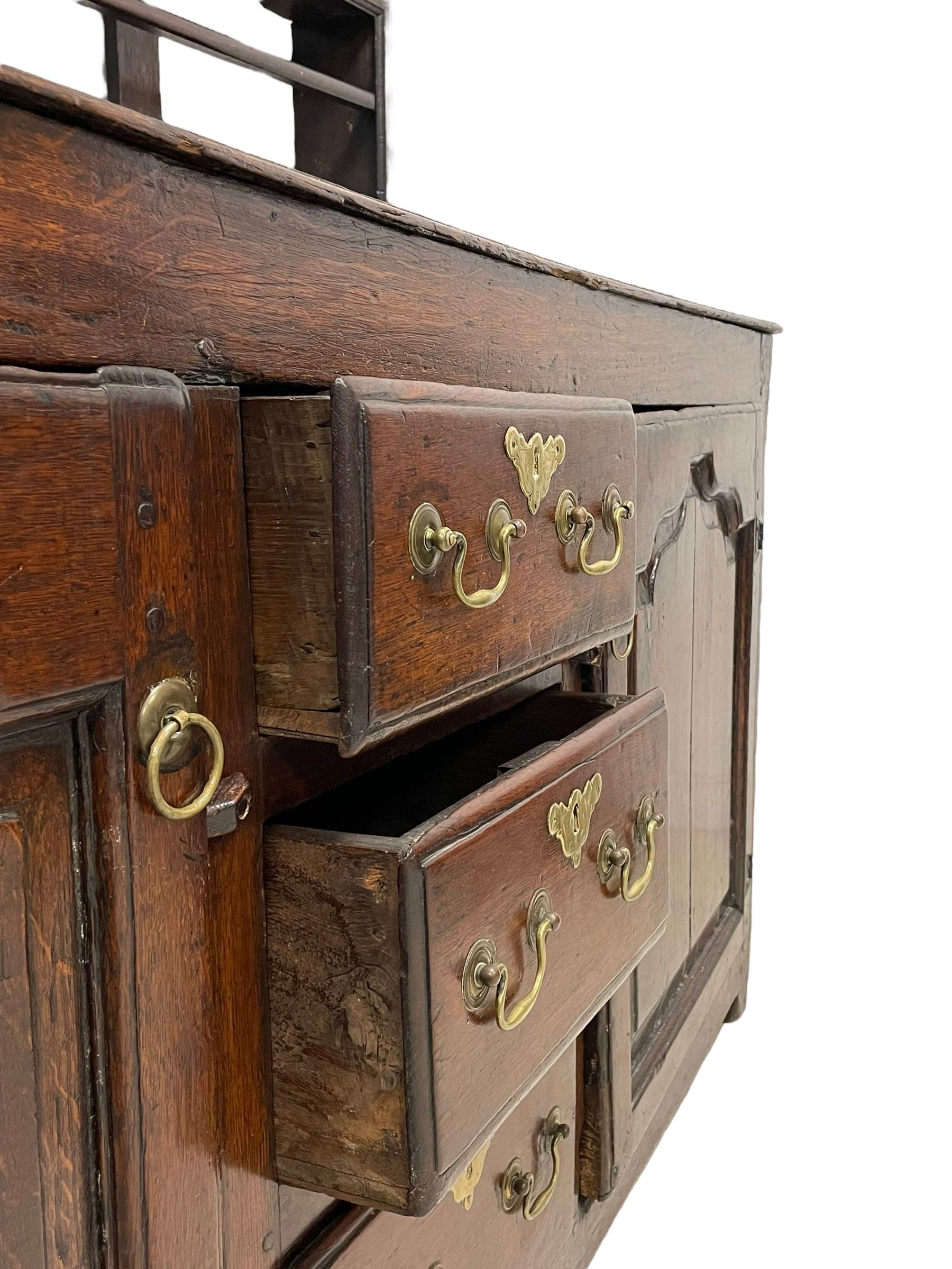 18th century oak dresser, projecting cornice over three heights plate rack with three small drawers, rectangular ovolo-moulded top over three central drawers and two flanking cupboards, enclosed by fielded panelled doors, on stile supports 